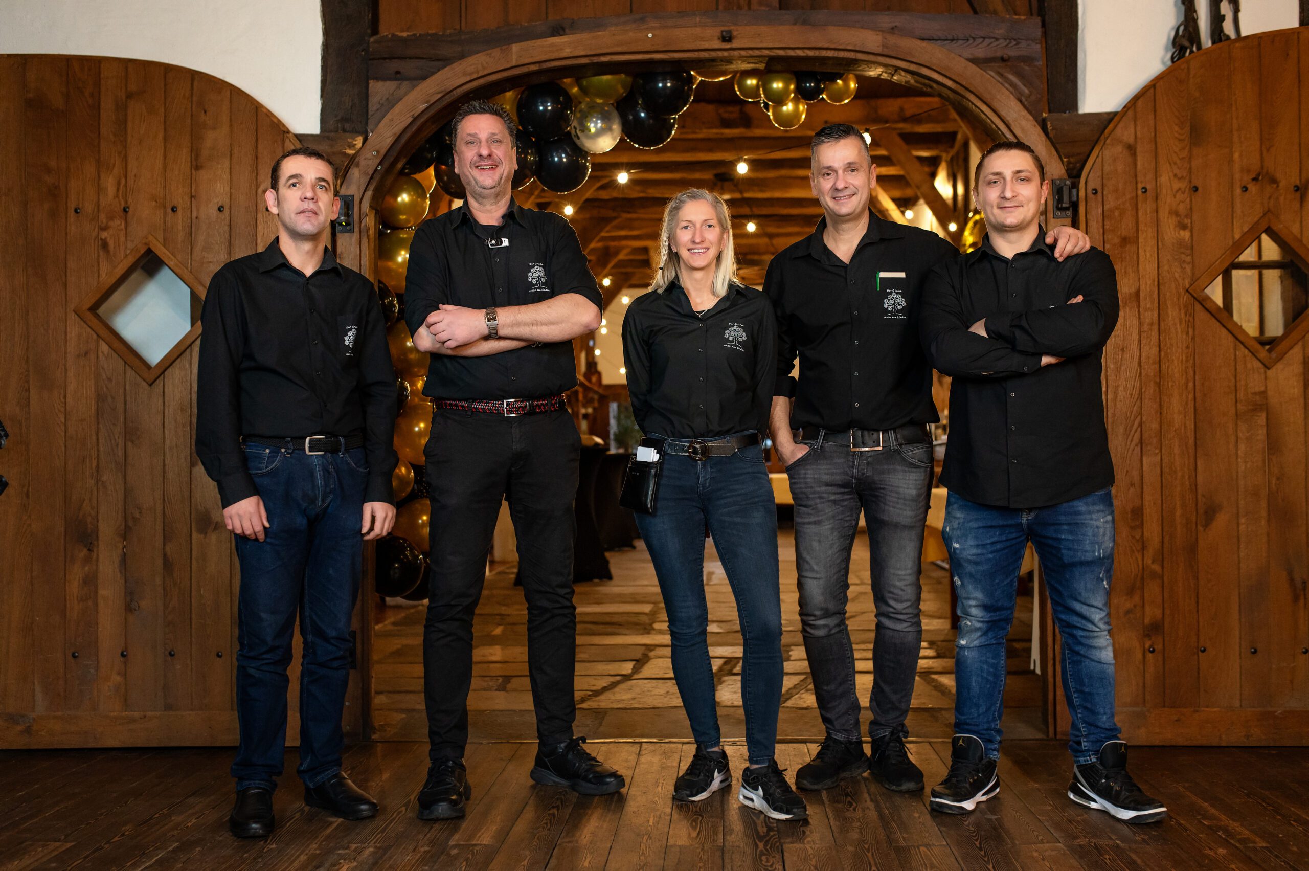 restaurantteam-professioneller- service- gastfreundschaft- kulinarisches -erlebnis erstklassigKML_0551 Teamfoto des Servicepersonals im Restaurant „Der Grieche unter den Linden“, lächelnd vor dem Eingang.
